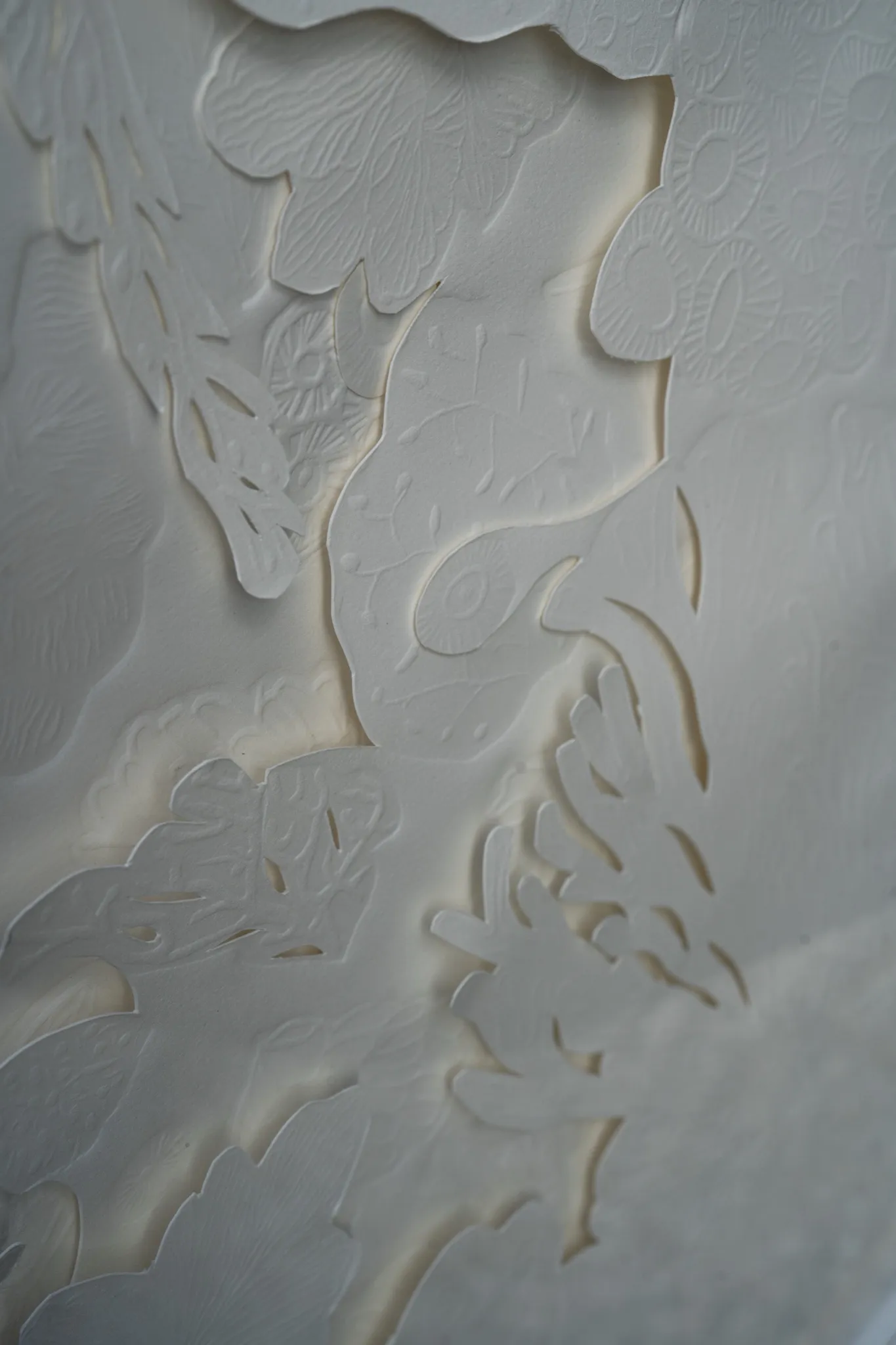 Detail of Mar de Seto in low light. Layers of cut paper overlap down the sheet, each edge traced by a narrow shadow.